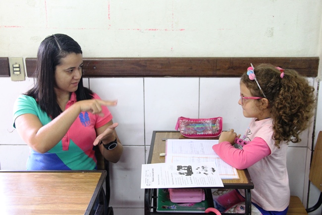Aluna com deficiência auditiva da Escola Estadual São Bento assiste atenta ao apoio dado pela intérprete de Libras. Foto: Franciele Xavier (SEE/MG)